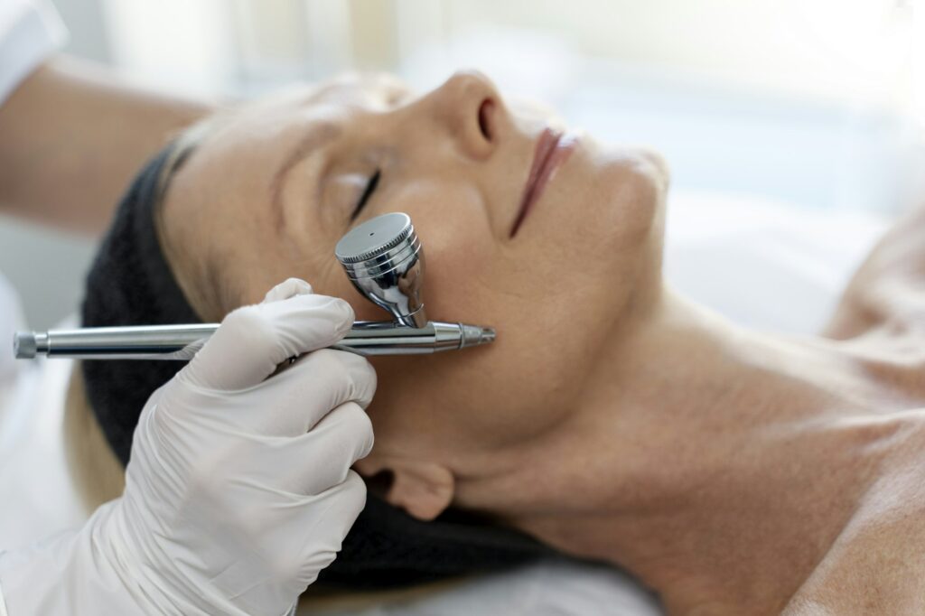 Caucasian woman receiving face oxygen peeling at cosmetology center