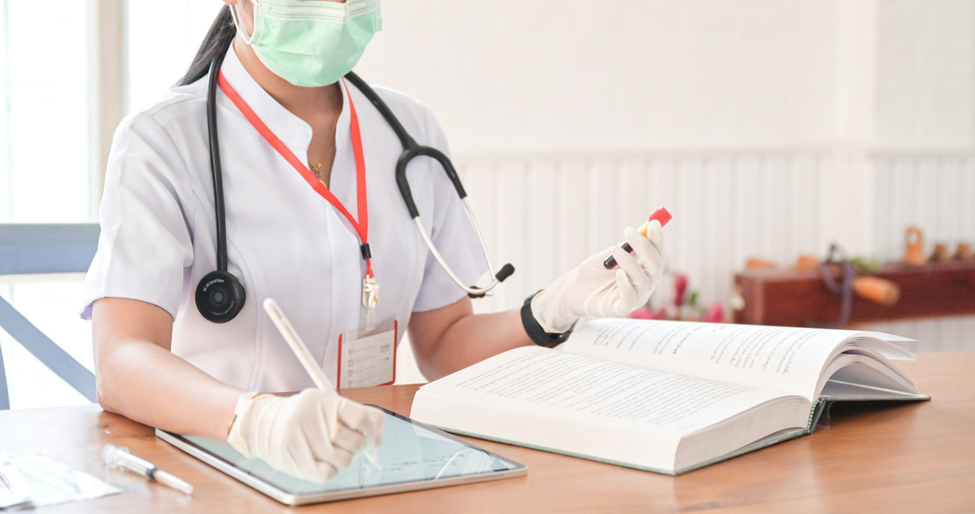 The doctor is recording the results of the blood test tube with a tablet.